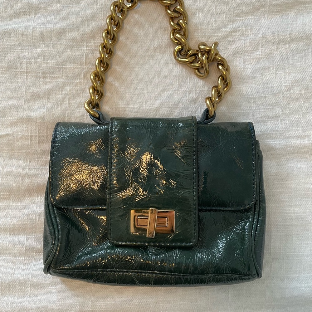 Mini teal faux leather bag with a gold chain.